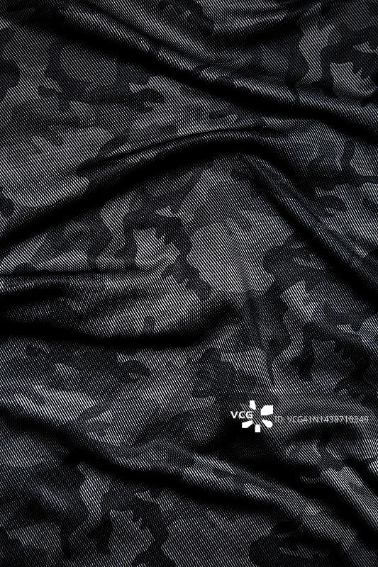 迷彩图案。时髦的深灰色迷彩面料。军事上的纹理。黑暗的背景。图片素材