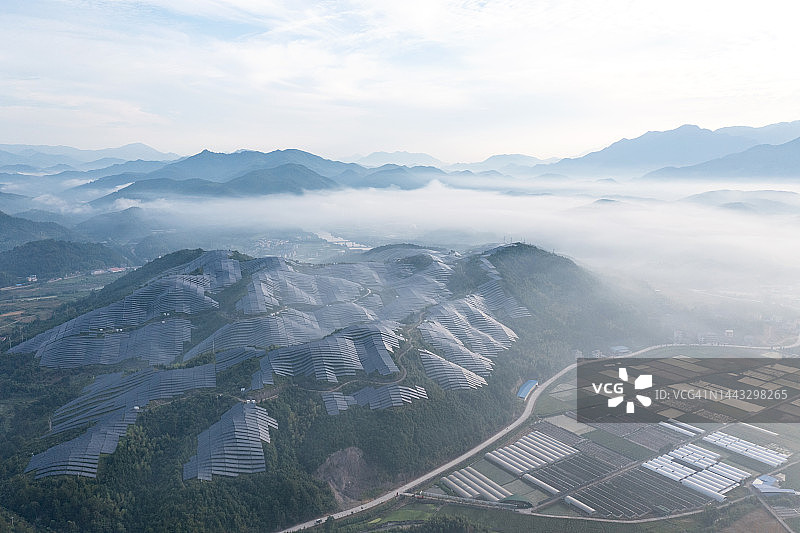无人机视角的农场山顶太阳能发电厂在雾中图片素材