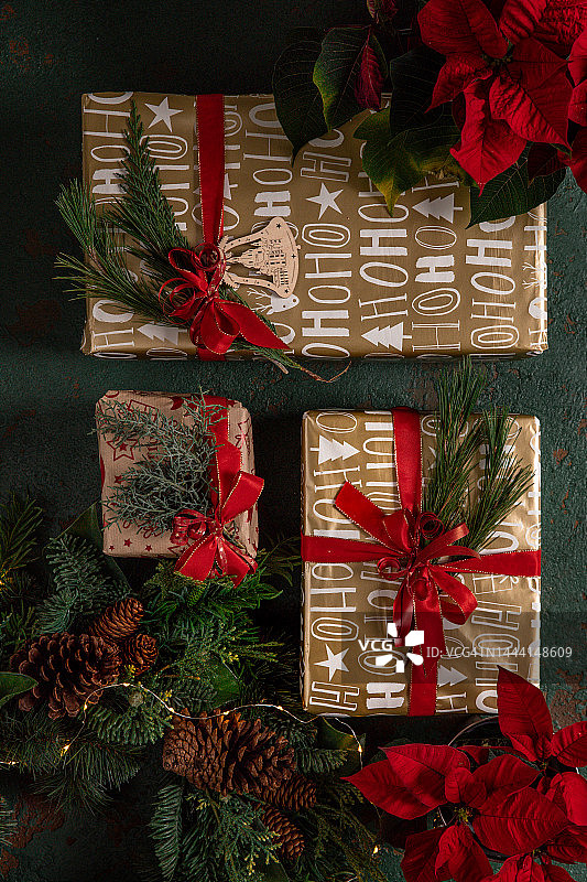 用红丝带、蝴蝶结和松科树枝包装的圣诞礼物图片素材