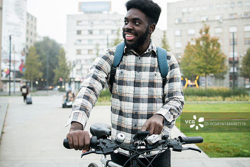 年轻人骑着电动自行车穿过城市图片素材