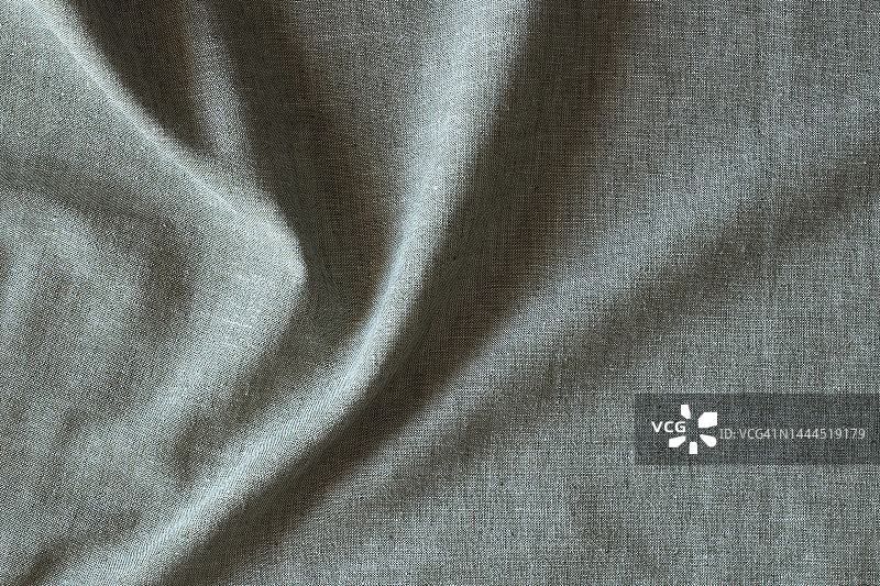 抽象褶皱亚麻织物质地背景。天然淡绿色染色亚麻布有机生态纺织品帆布底色。俯视图图片素材