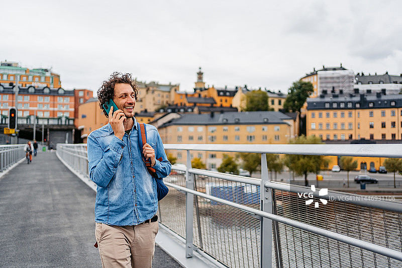 年轻男子在斯德哥尔摩的桥上散步时打电话图片素材