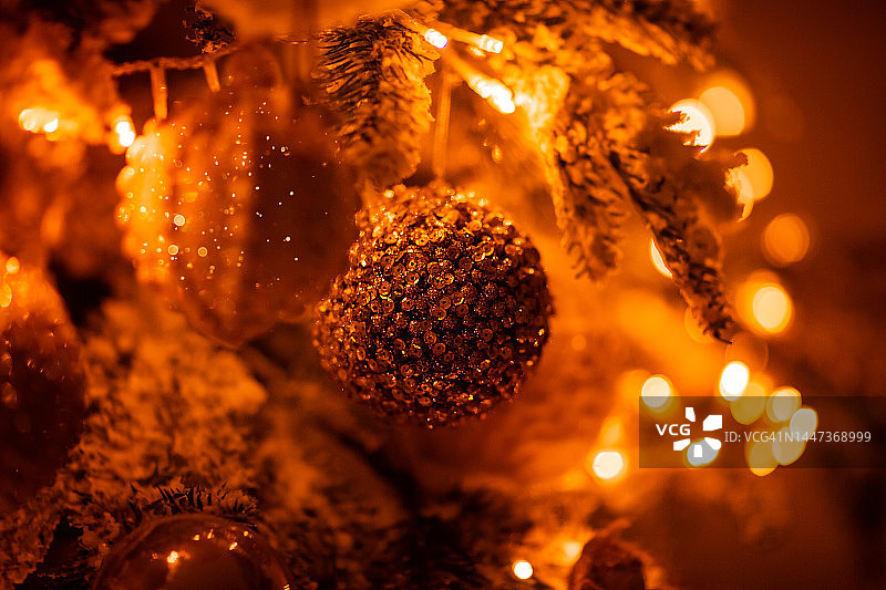 圣诞球，圣诞装饰挂在圣诞树上，特写。花环在附近闪闪发光图片素材