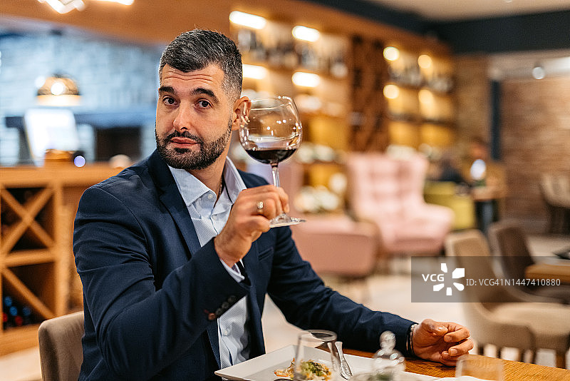 中年男子在餐厅用红酒敬酒图片素材