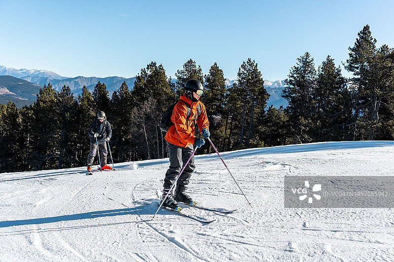 两个男孩站在满是雪的滑雪场上。图片素材