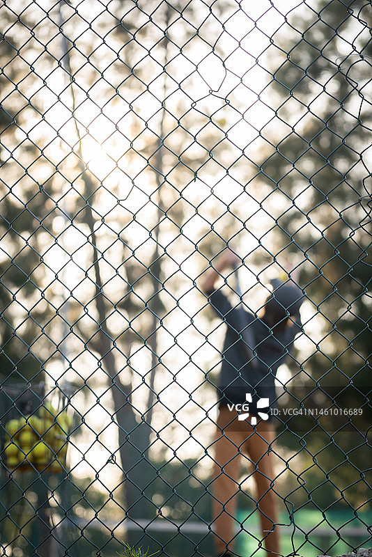 一个小男孩在网球训练中练习发球的完整镜头图片素材