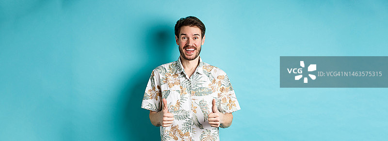 在夏威夷衬衫兴奋微笑的游客展示大拇指图片素材
