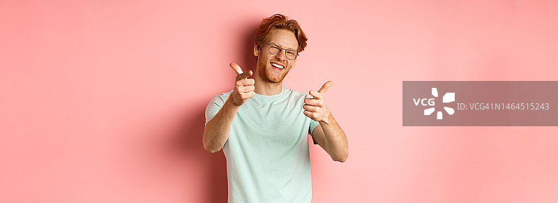 快乐的年轻人红头发和胡子，戴眼镜，眨眼和图片素材