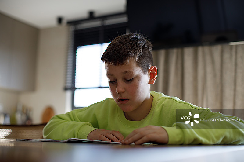 男孩在做他的作业或家庭作业图片素材