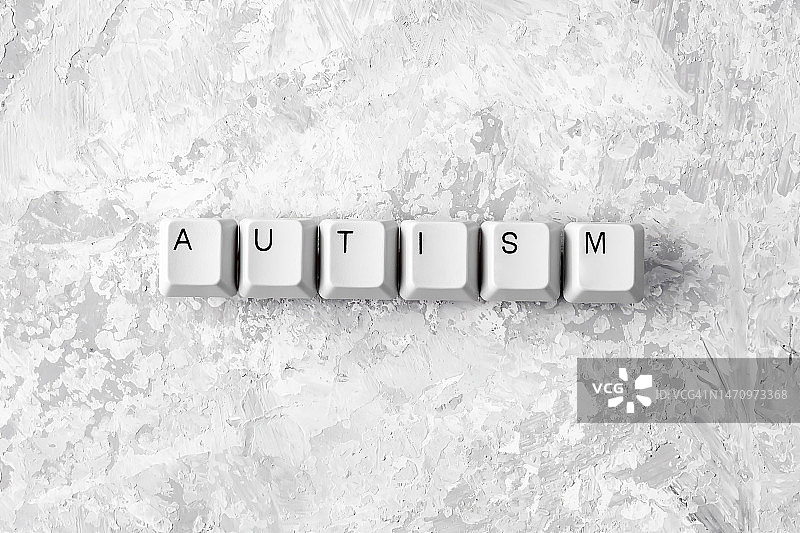 用电脑键盘在灰色背景上书写的自闭症单词。概念上的形象。图片素材