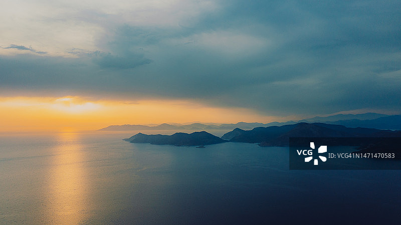 在土耳其Oludeniz的水晶蓝色的大海和岛屿上，戏剧性的日落鸟瞰图图片素材