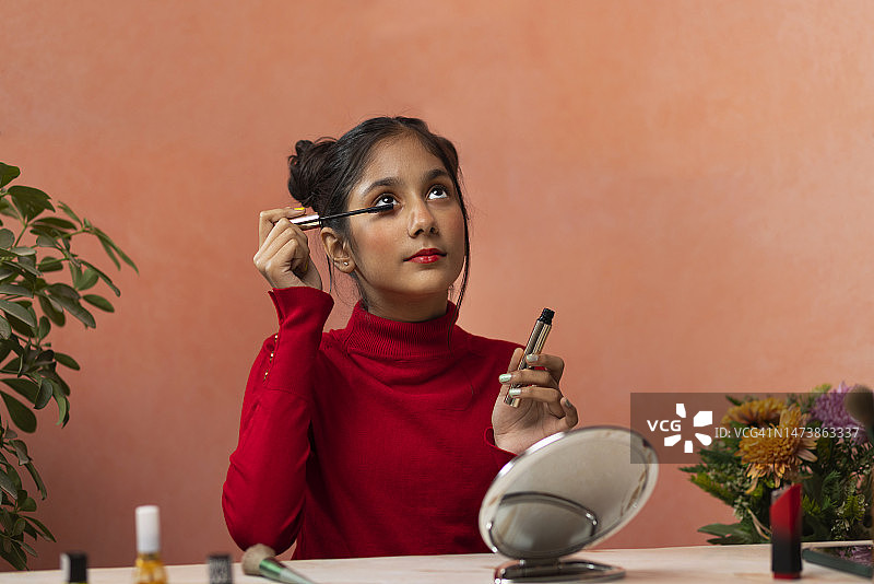 一个十几岁的女孩用睫毛膏的肖像图片素材