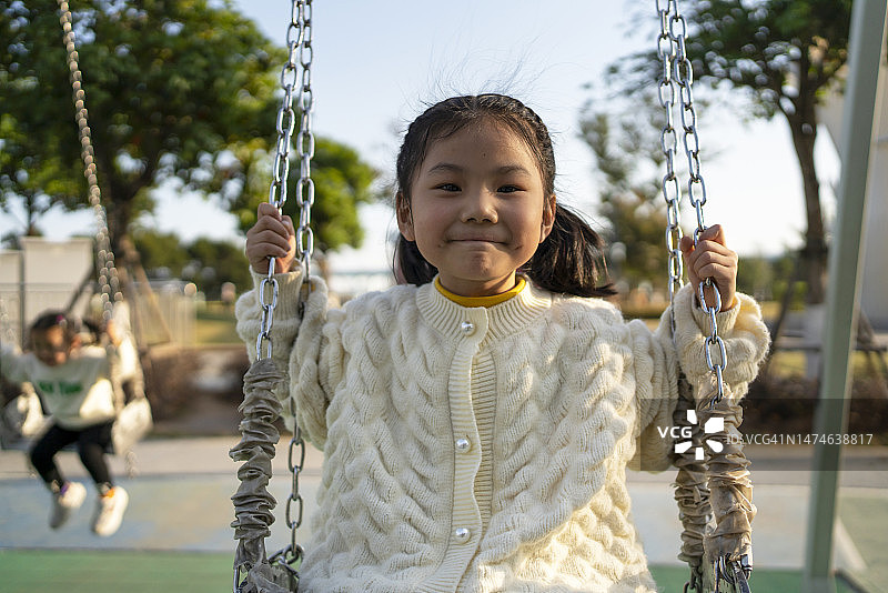 快乐的亚洲小女孩正在荡秋千图片素材