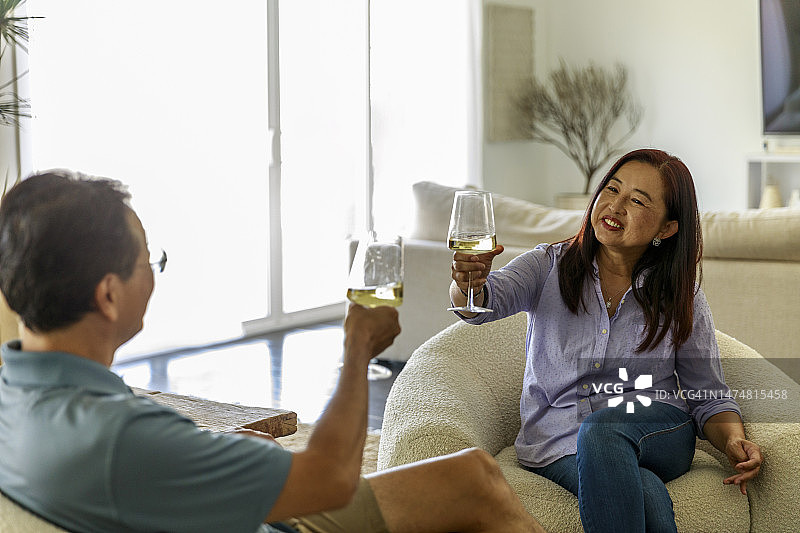 幸福的成熟夫妇举杯酒，坐在度假屋图片素材