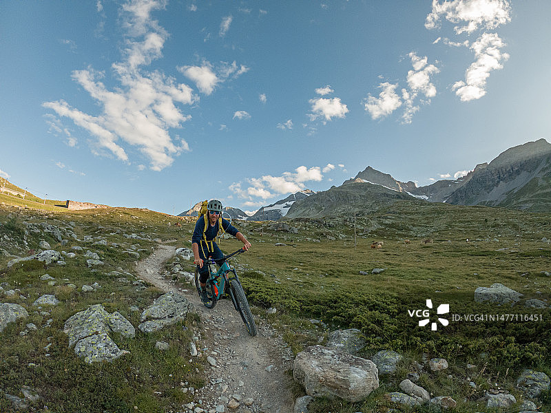 山地车手从阿尔卑斯山脉的小道上下来图片素材