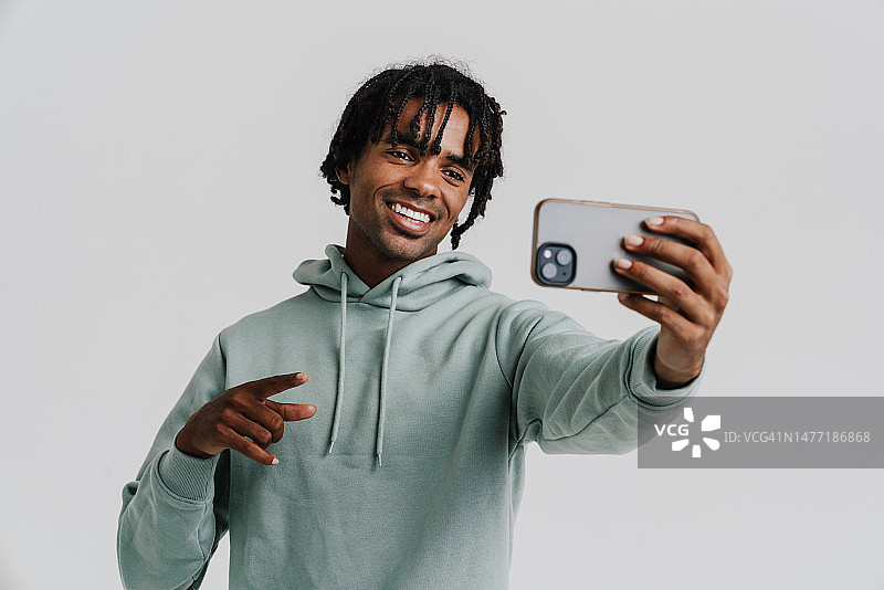黑人青年在用手机自拍时打手势图片素材