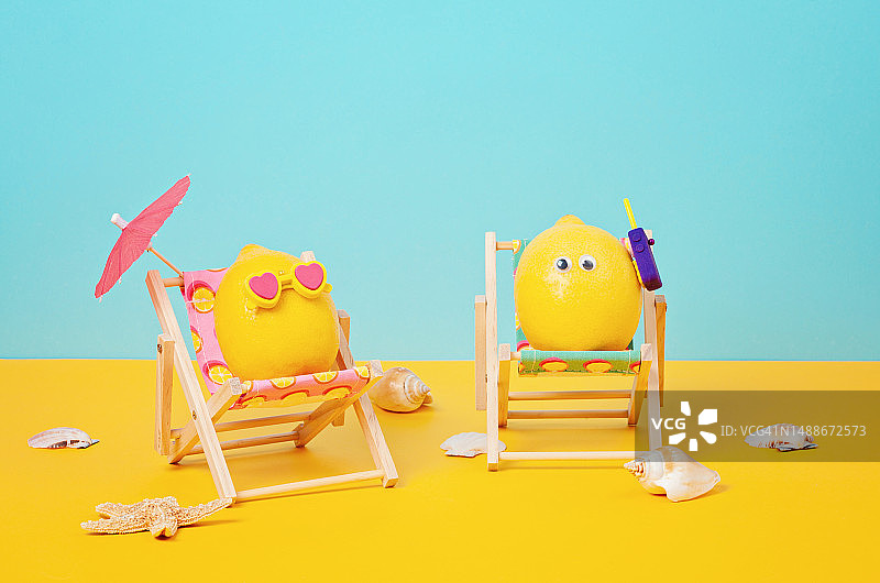 罗马尼亚海滩上，柠檬戴着墨镜，打着伞躺在日光浴床上图片素材