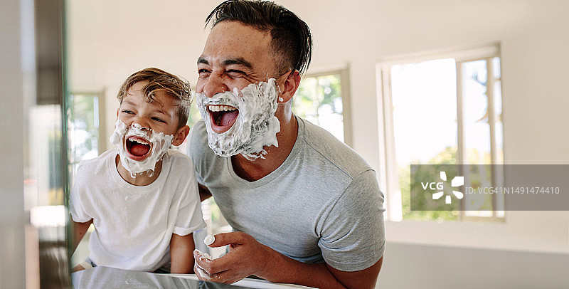 父亲节趣事:爸爸和儿子一起刮胡子，玩得很开心图片素材