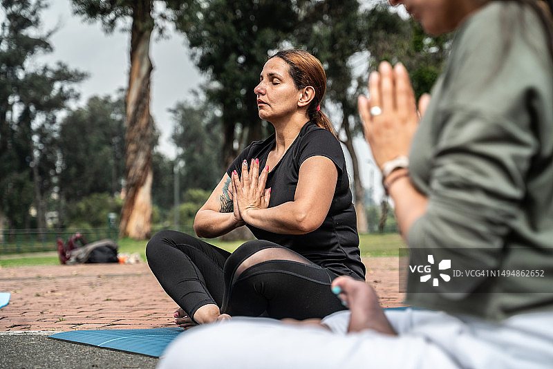 一个在公园瑜伽课上冥想的成熟女人图片素材