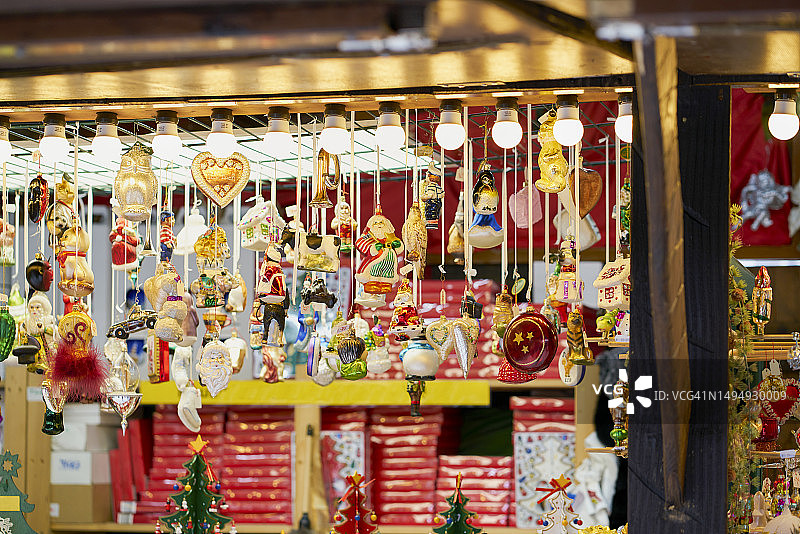 这是一个被白色灯泡照亮的市场摊位，里面摆满了圣诞装饰品。图片素材