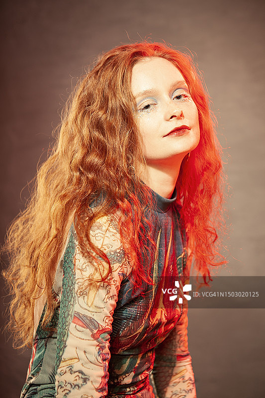 一个年轻漂亮的红发女人的艺术肖像，她的妆容很有艺术感。使用的光效图片素材
