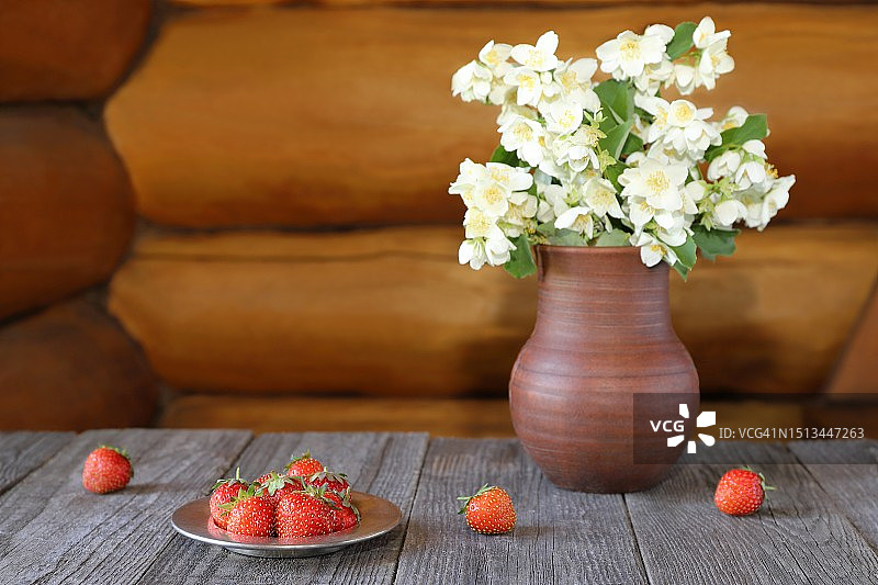 陶器花瓶里的草莓和花束。图片素材