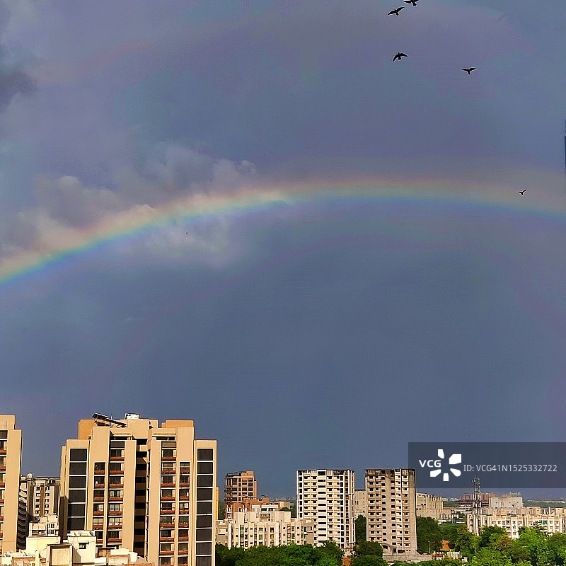 大雨/季风过后，傍晚太阳出来后，彩虹在艾哈迈达巴德的天际线上形成图片素材