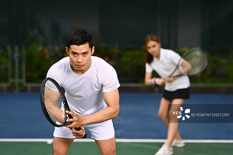 网球运动员站在准备接发球的位置，为比赛在球场上练习。图片素材