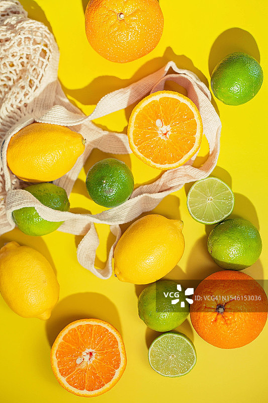 平面布局——在黄色背景上放置酸橙、柠檬和橙子图片素材