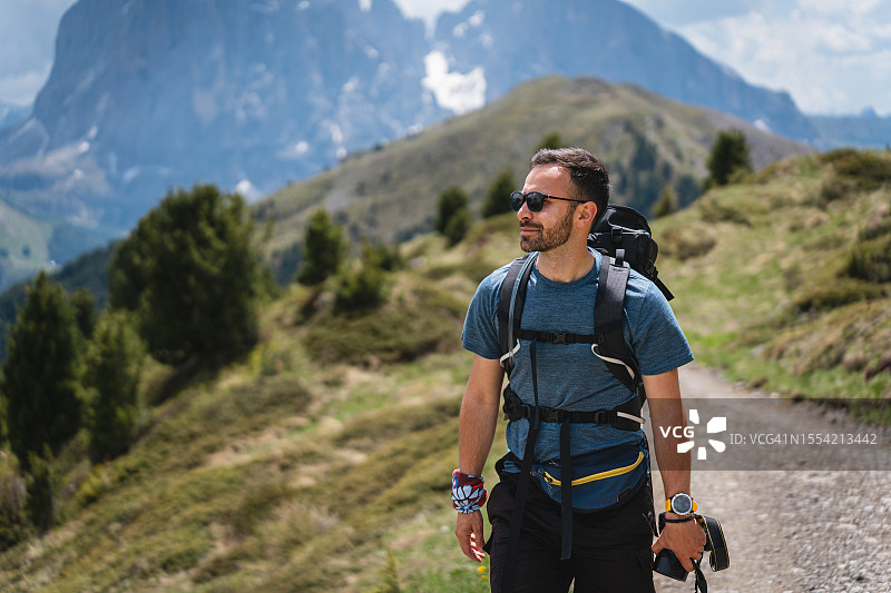 男性高加索徒步旅行者拿着相机欣赏塞塞达阿尔卑斯山脉的景色图片素材