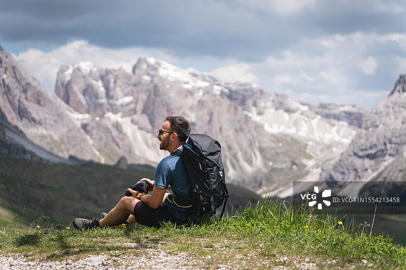 一名高加索男子，在徒步旅行中休息，欣赏塞塞达阿尔卑斯山脉的景色图片素材