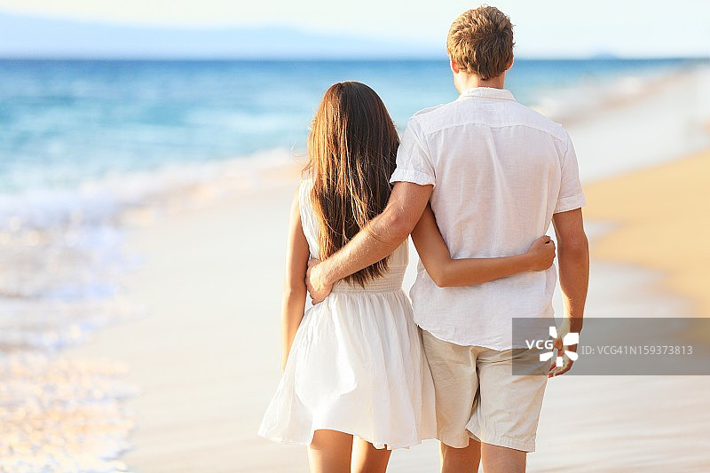度假情侣在海滩上散步图片素材
