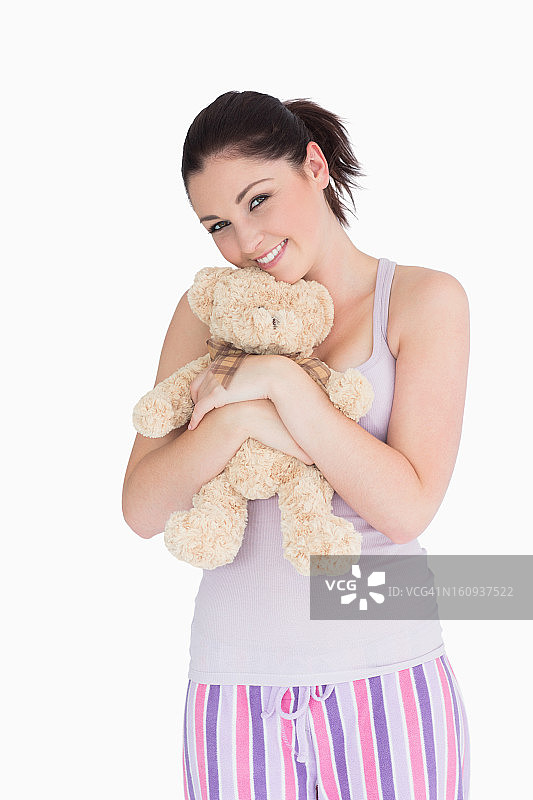 微笑的女人抱着一只泰迪熊图片素材