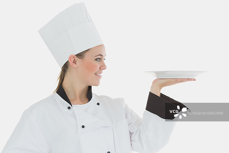 女厨师看着一个空盘子图片素材
