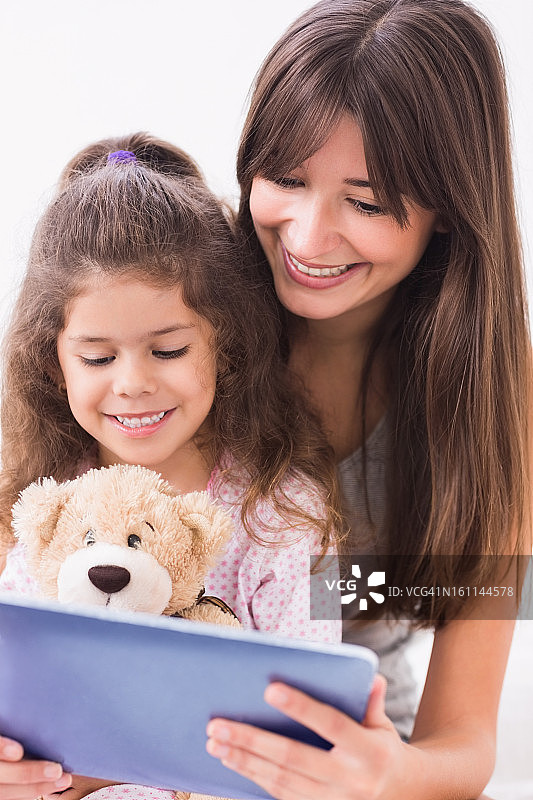 快乐的母亲和女儿使用平板电脑图片素材