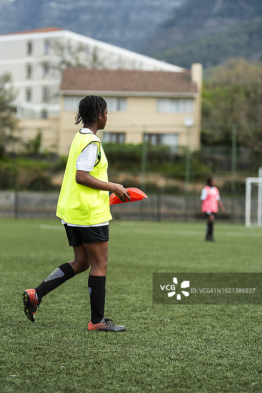 女足运动员在球队训练时在场上放置踢球标记图片素材