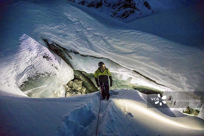 攀爬者用绳索从冰洞中下降图片素材