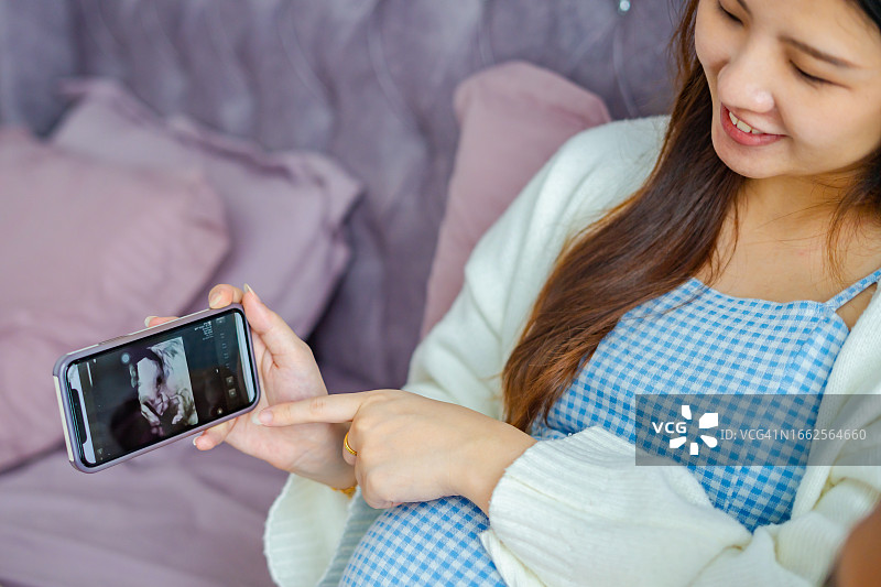 孕妇在手机上看宝宝的扫描图图片素材