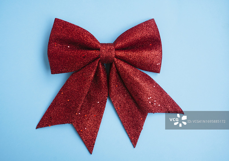 蓝色背景上的大圣诞红蝴蝶结装饰图片素材