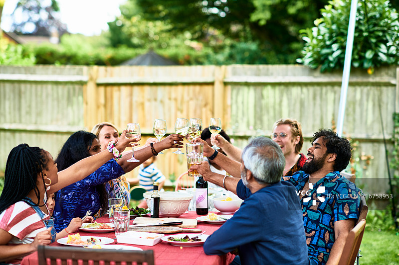 多种族朋友在花园里举杯庆祝图片素材