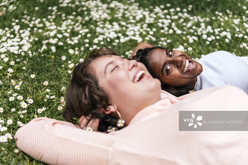 微笑的朋友躺在草地上笑图片素材