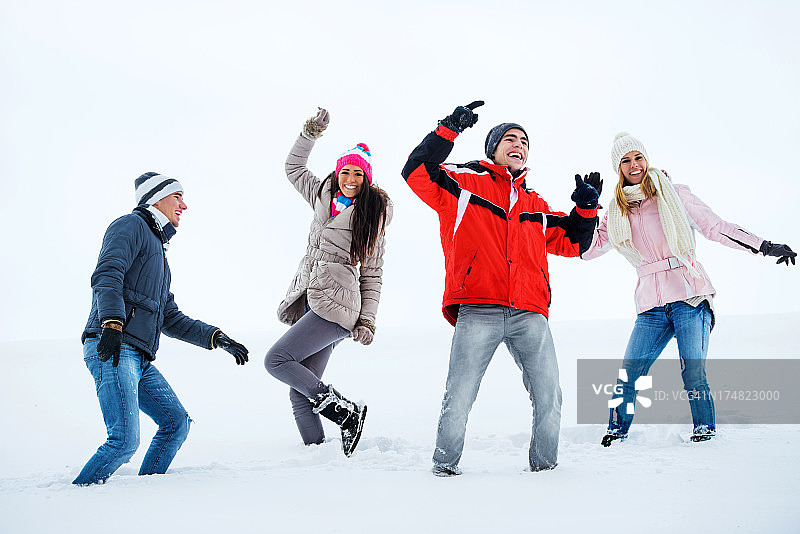 一群兴高采烈的年轻人在雪地里享受。图片素材