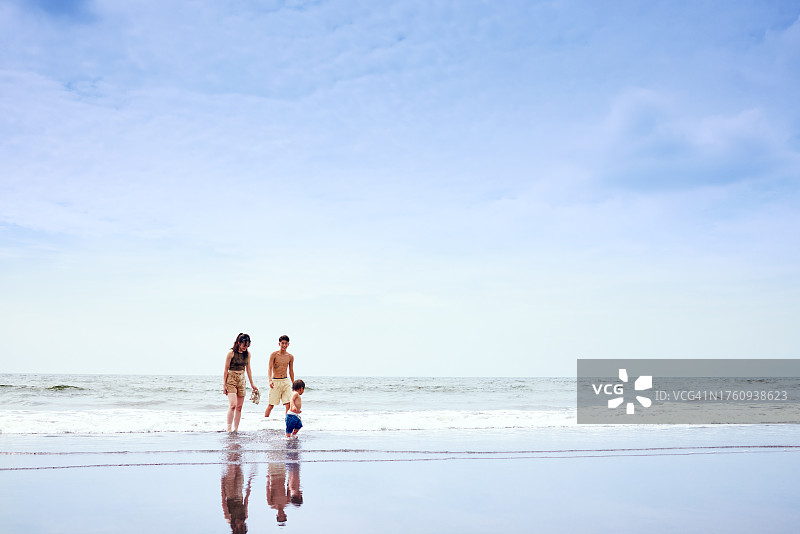 父母和孩子在沙滩上散步图片素材