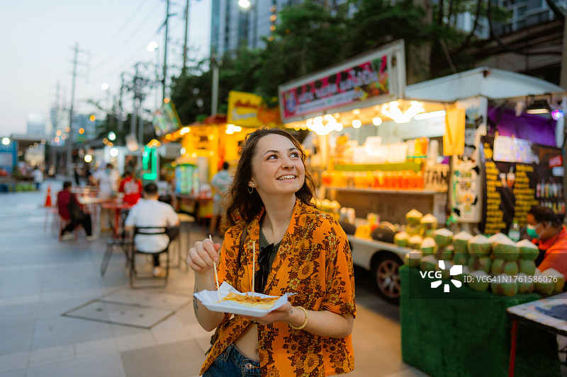 度假期间，一名女子在曼谷夜市吃泰国煎饼(roti)图片素材