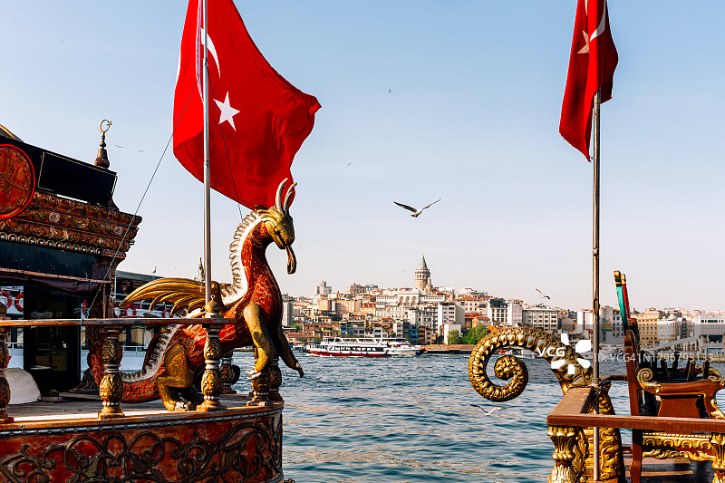 土耳其，伊斯坦布尔的天际线上有一艘船上的龙雕塑图片素材