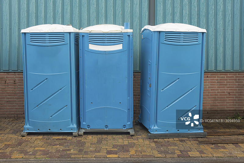 三个蓝色的移动生态厕所彼此相邻图片素材