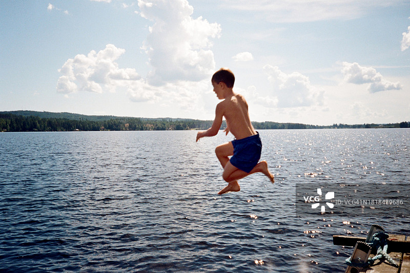 在瑞典，一个小男孩跳入湖中图片素材