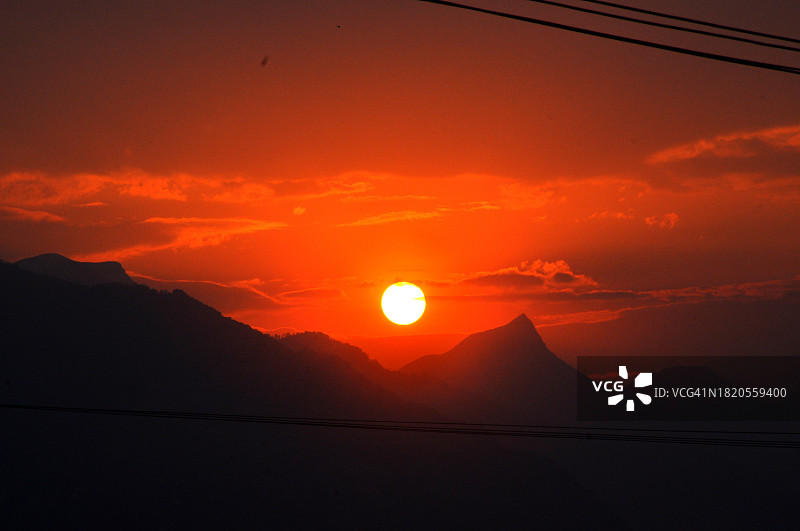 橙色天空映衬下群山剪影的美景图片素材