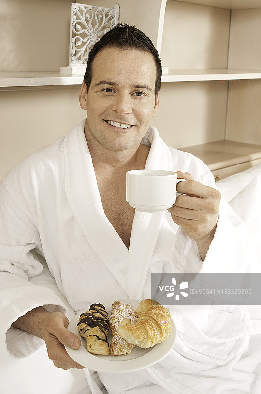 帅哥在酒店房间享用早餐图片素材
