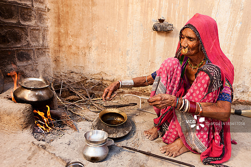 准备食物的印度老妇人。俾斯诺依村再驱车。拉贾斯坦邦。图片素材
